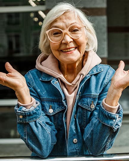 Older woman smiling confidently after dental implant treatment